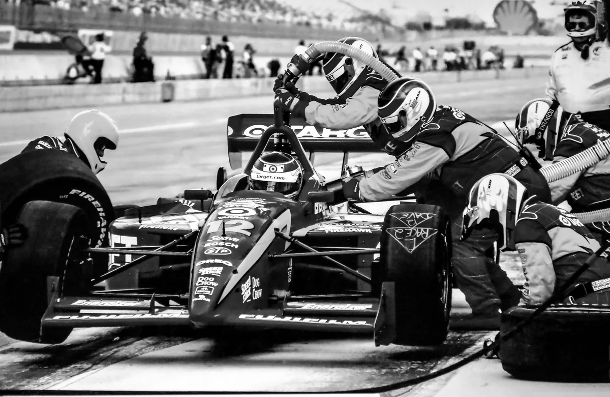 Pit crew changing tyres on a race car