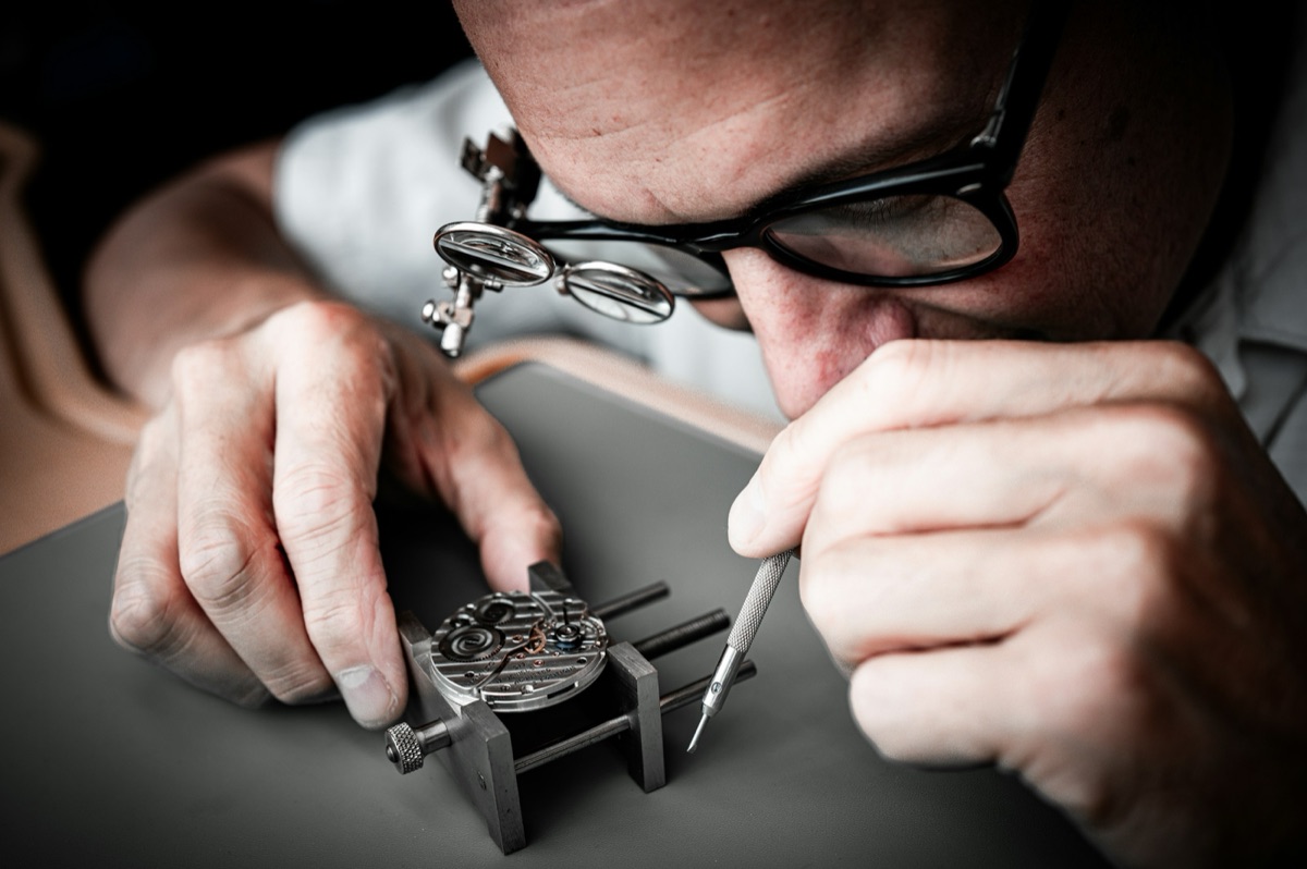 A watchmaker at work with a loupe